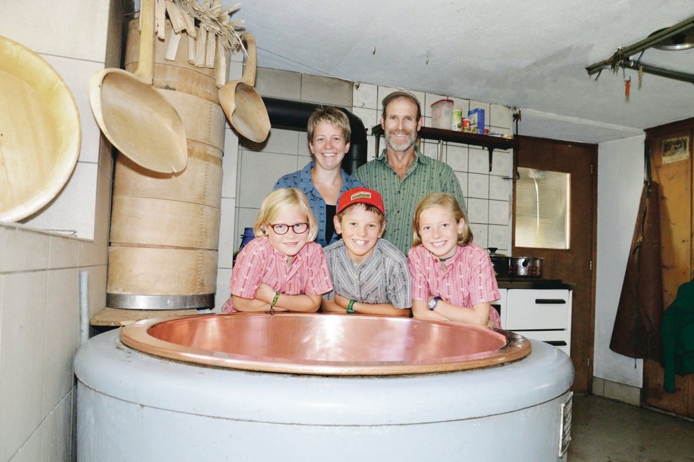 Myrtha und Siegfried Fischli mit den Kinder Nina,  Marc und Sara (v. l. n. r.) hinter dem Kessi, in dem sie den Alpziger herstellen.(Bilder Barbara Schirmer)