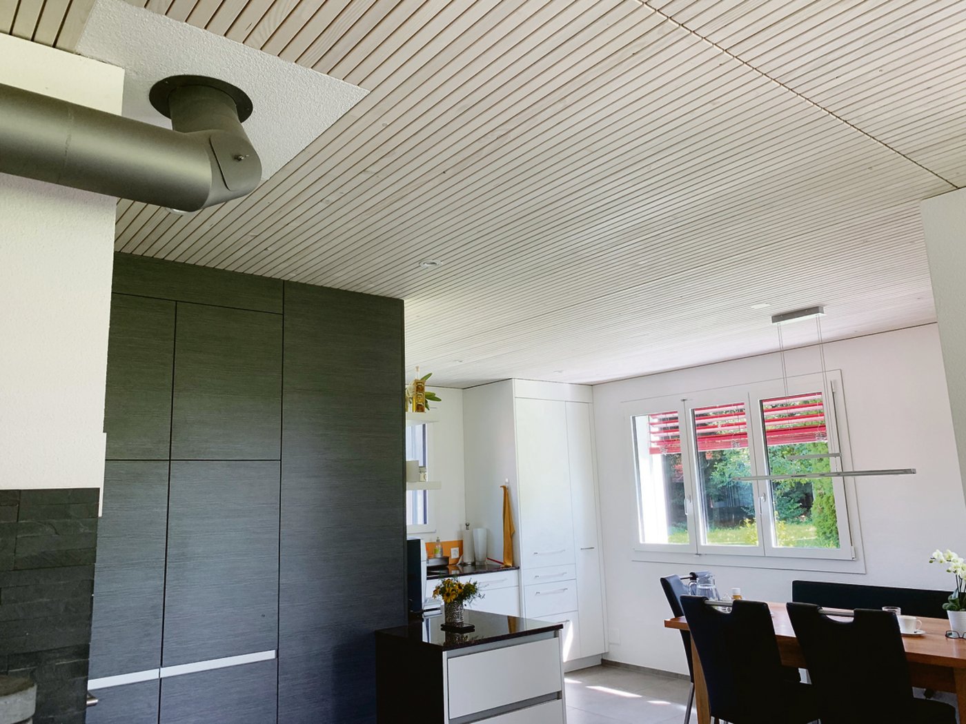 Blick in die Küche, die Decken im ganzen Haus sind im System Bresta mit Holzlamellen erstellt.