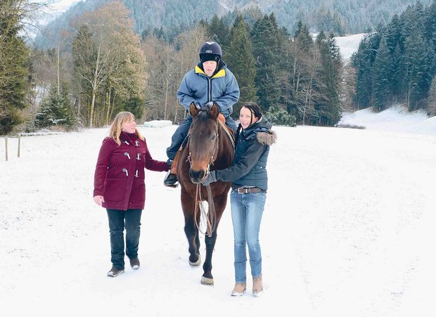Michaela Schnyder (rechts) führt ihre Quarter Horse-Stute Olena und unterstützt gleichzeitig André bei der Reittherapie. Seine Begleitperson Luzia Wangeler hilft auf der anderen Seite. (Bild Andrea Gysin)