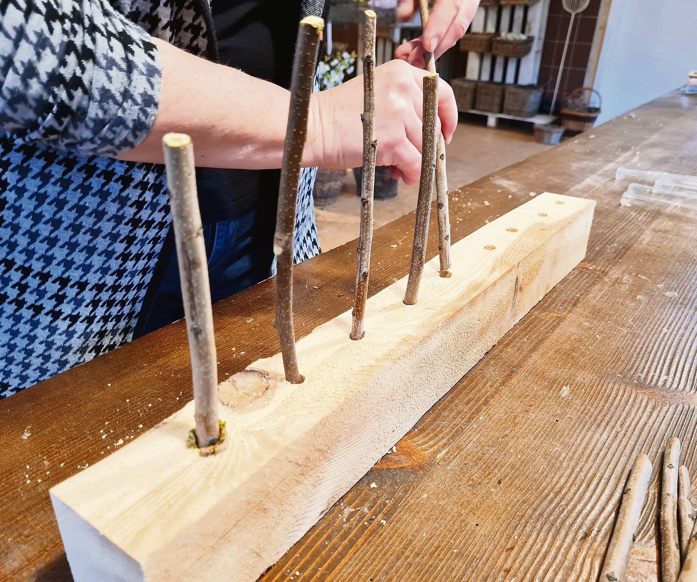 Die Haseläste in die Löcher stecken.