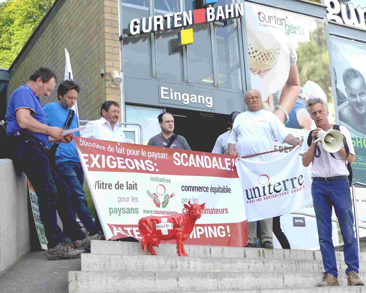 Am Fusse des berner Hausbergs Gurten verkündet Rudi Berli die Forderungen von Uniterre. Konrad Klötzli von der IG-Anbindestall wird es ihm kurze Zeit später gleichtun und die Abschaffung der Lactofama fordern. 