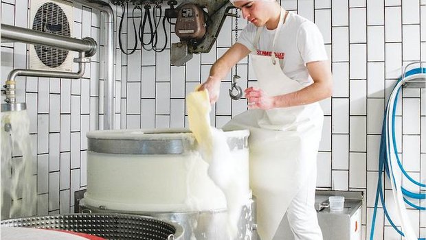 Claudio Macaluso schöpft in der Käserei in Tägertschi BE Molkeschaum aus der Käsepresse. (Bild hja)