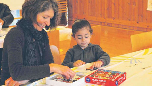 Eine Landfrau spielt mit einem Flüchtlingskind: Im Gemeinde-Mehrzweckraum konnten gemütliche Stunden verbracht werden. So rückten Krieg und Flucht kurz in den Hintergrund. (Bilder S. Gasser)