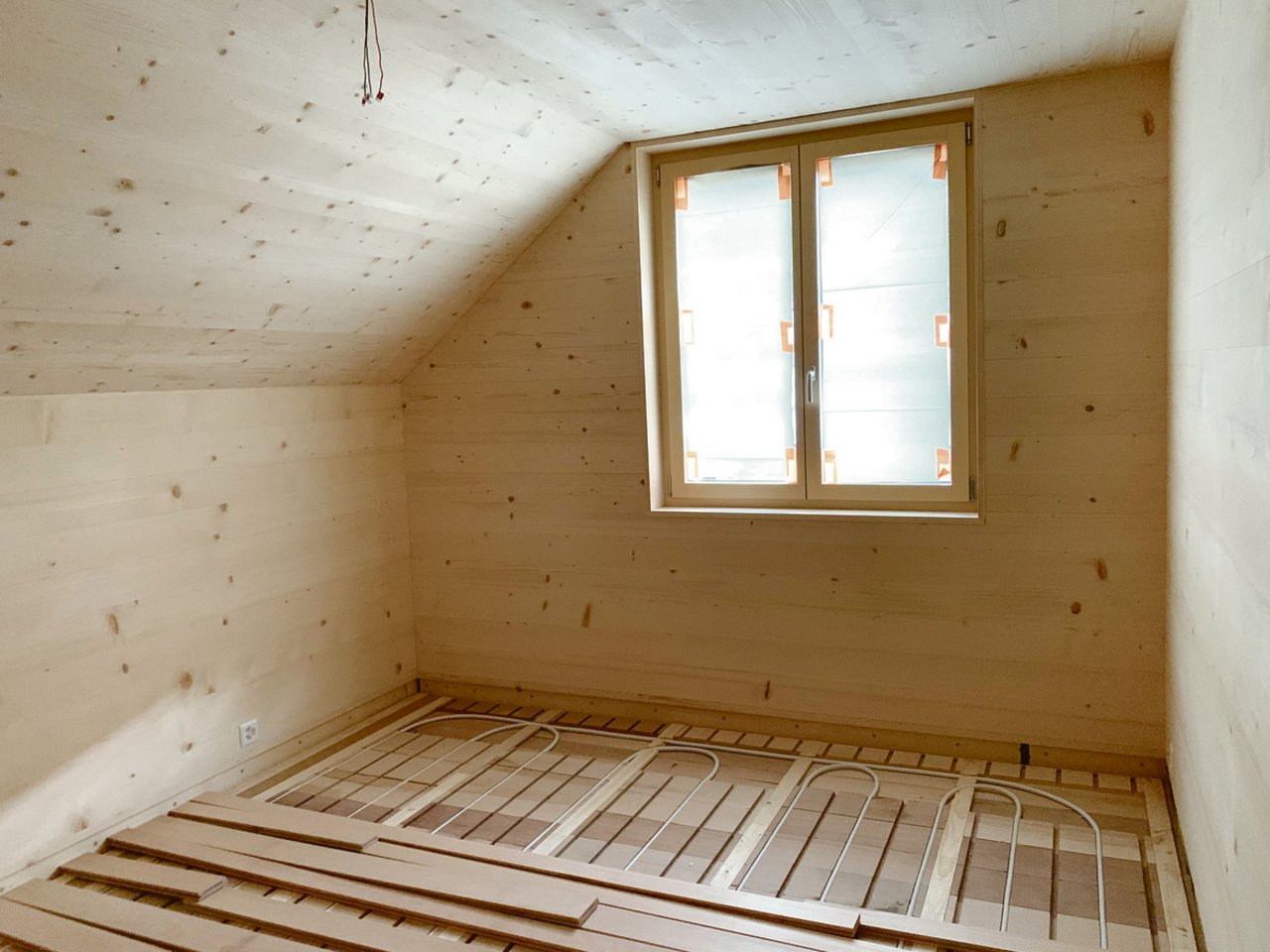 Massiver Bodenaufbau in Holz. Die Bodenheizung ist direkt in die ausgefrästen Buchenbretter eingelegt. 