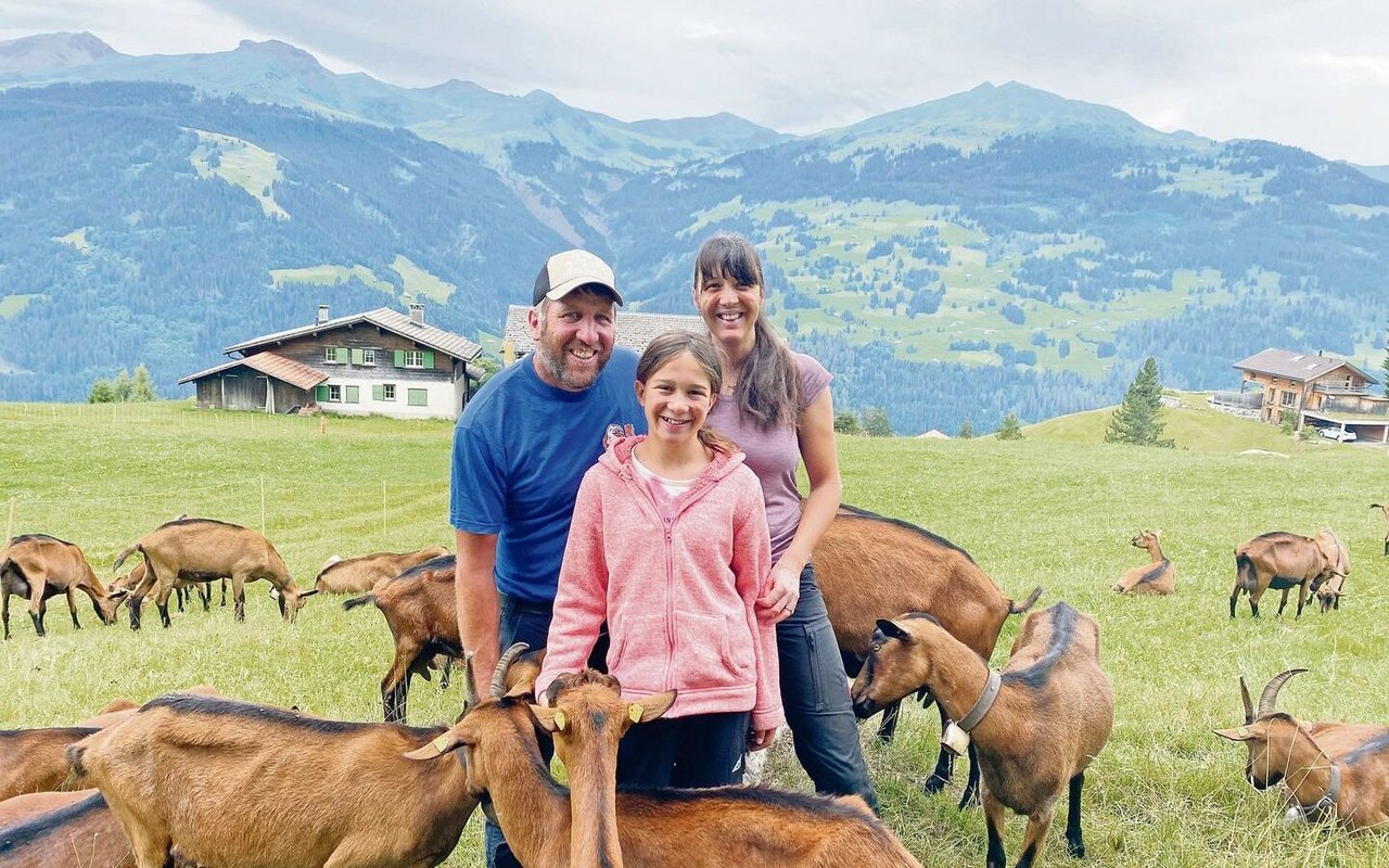 Ladina Lötscher mit Ehemann Abraham Lötscher und der jüngsten Tochter Svenja auf der Geissenweide. Die Herde besteht vorwiegend aus Tieren der Rasse Gemsfarbige Gebirgsziege. Sie werden von Dezember bis Oktober gemolken.