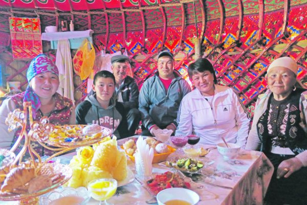 In Kirgisien scheint Absatzförderung über Begeisterung, Geschmack und Gastfreundschaft zu laufen: reichgedeckte Teetafel und Gastgeberfamilie.(Bild Esther Thalmann)