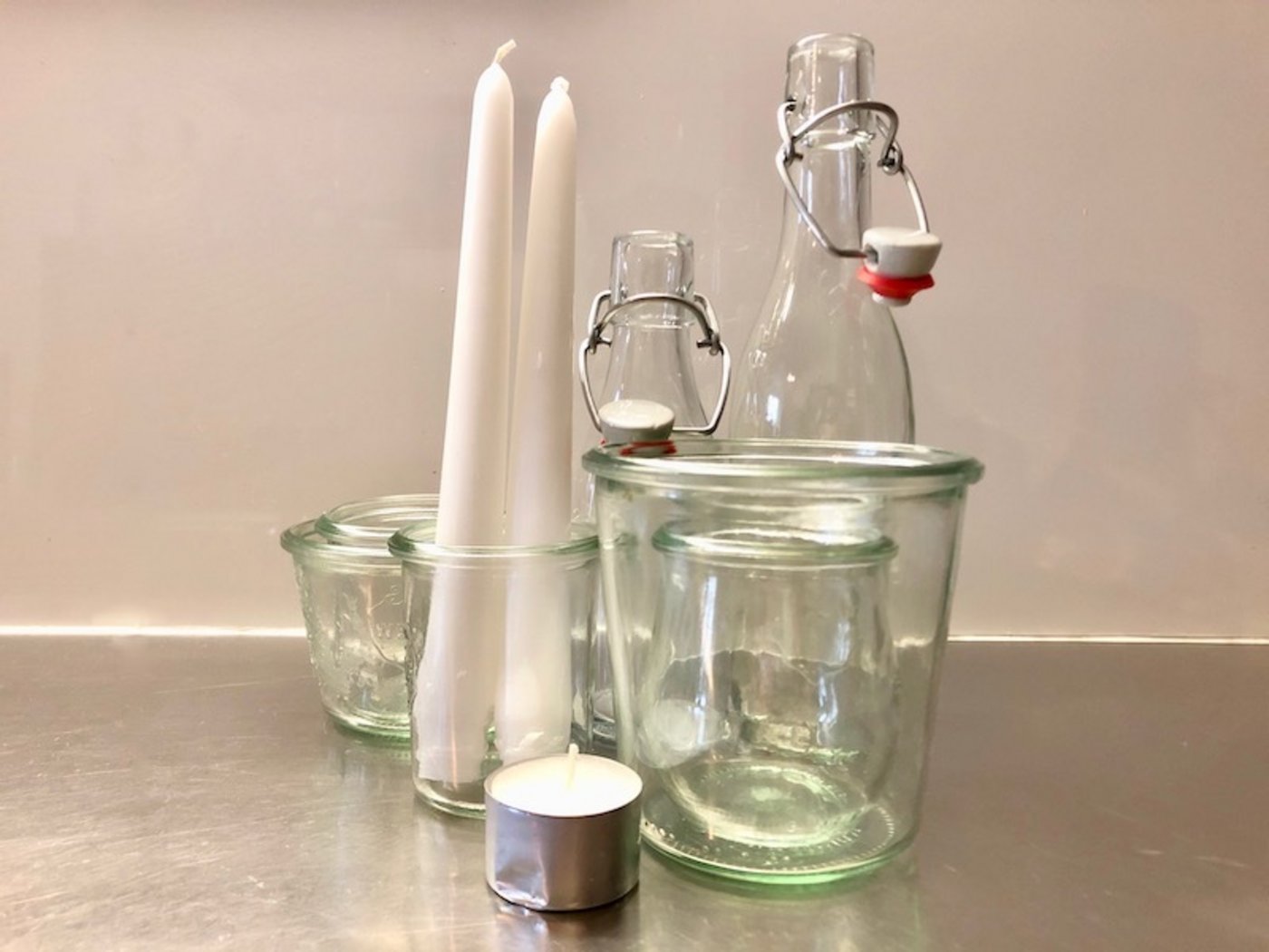 Gläser, Flaschen und Kerzen.