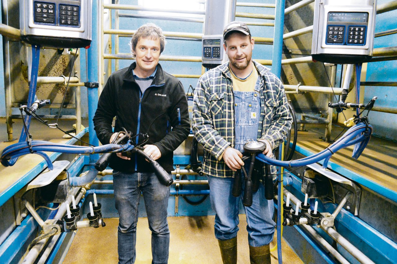 Urs Schmid (links), Produktleiter bei DeLaval in Sursee LU, im Stall bei Lionel Kolly aus Pont-la-Ville FR, der das neue Evanza-Melkzeug als Pilotbetrieb seit zwei Monaten nutzt. (Bilder Peter Fankhauser)