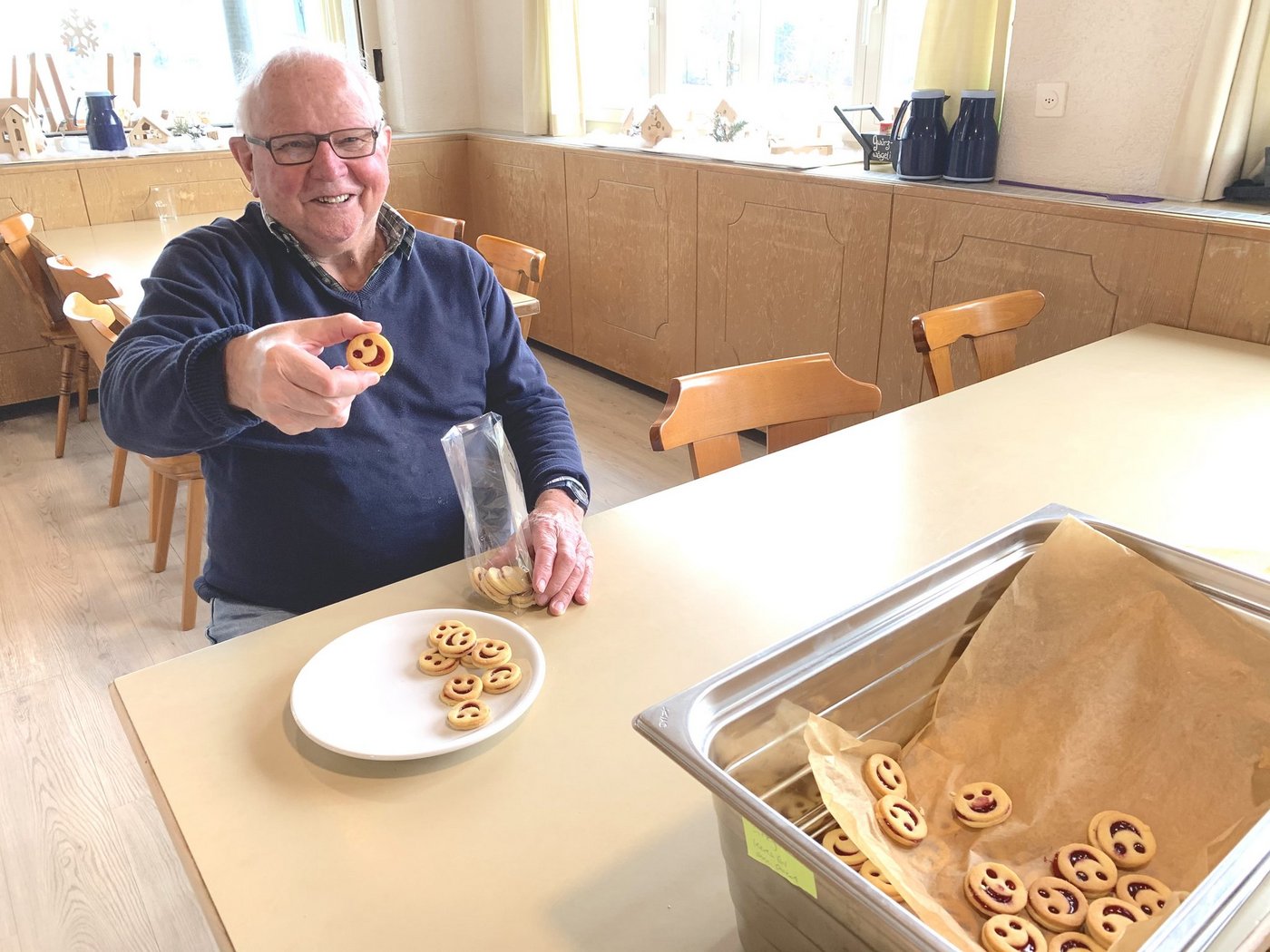 Robi Rölli im Speisesaal. In den letzten Wochen gab es viel zu tun mit Guetzli abpacken, hier Spitzbuebe. Für den Hofladen hilft er aber auch sonst viel, verarbeitet etwa Bohnen oder Kräuter.