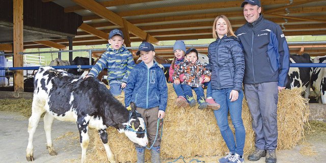 Zufrieden: Corinne und Pirmin Schüpfer mit Kindern in ihrem Anfang 2020 neu in Betrieb genommenem Milchviehstall. (Bild DeLaval)