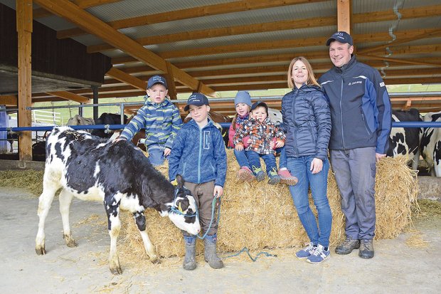 Zufrieden: Corinne und Pirmin Schüpfer mit Kindern in ihrem Anfang 2020 neu in Betrieb genommenem Milchviehstall. (Bild DeLaval)
