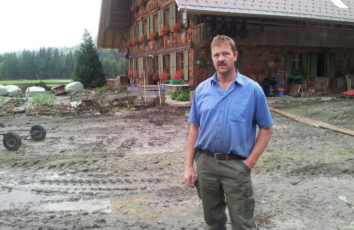 Der Brunnen wurde vom Wasser davon getragen, ebenso das Jauchefass. Landwirt Hans Gerber gestern Mittwochmorgen vor dem Bauernhaus. Wasser und Schlamm liefen durch die Gebäude (nächstes Bild) ... (Bilder: Simone Barth)