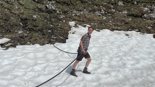 Alptagebuch: Wenn die Liebe zum Schnee dahinschmilzt wie Schnee Die Wasserschläuche werden wieder verlegt, noch immer liegt Schnee. (Bild Josef Fässler)