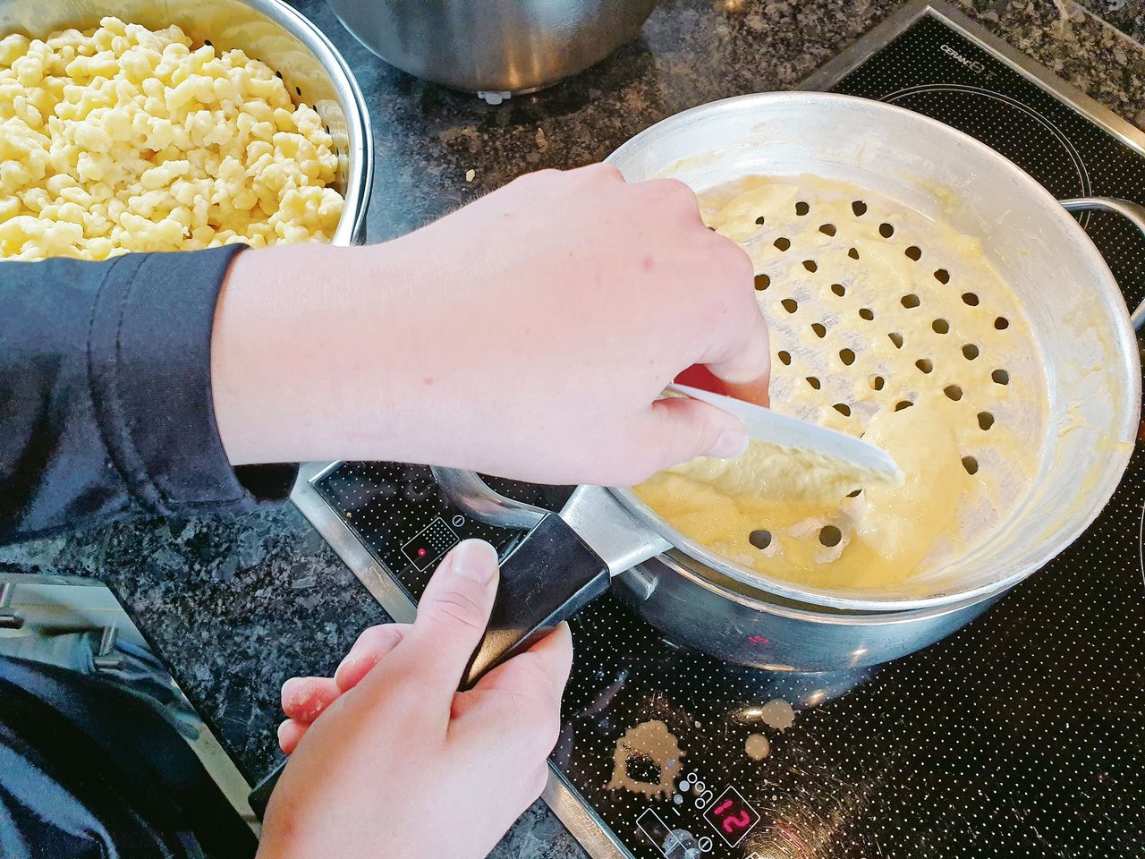 Aus Eiern, Flüssigkeit, Mehl und Salz entsteht der Teig. Oben rechts ist das Knöpflisieb im Einsatz, unten links werden Gnocchi mit der Schere aus dem Spritzsack ins kochende Wasser portioniert. Es gibt schnellere Mahlzeiten – aber das Resultat überzeugt.