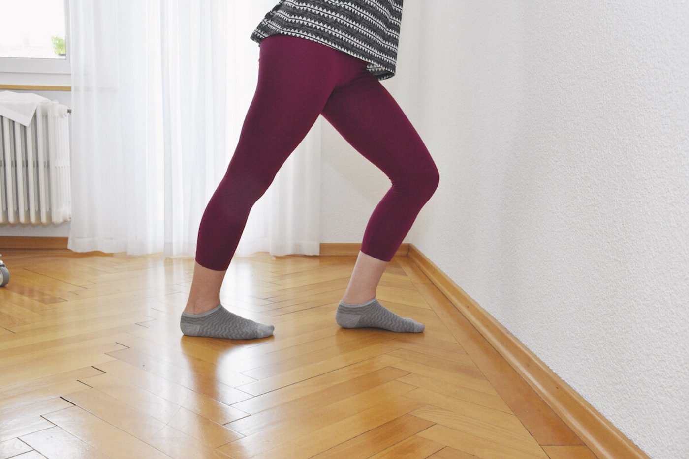 Für Ferse und Wade: Hände an der Wand abstützen. Einen Fuss vor den anderen, Füsse paralell. nach vorne lehnen. Das vordere Knie beugen, das hintere gesteckt lassen. Halten, wechseln, wiederholen. (Foto: Cornelia von Däniken)