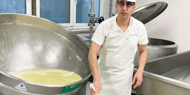 Mozzarella-Herstellung ist hier Handarbeit: Roberto De Matteis entnimmt dem Bottich den Käsebruch, um ihn anschliessend zu rühren, zu kneten und auseinander zu ziehen.