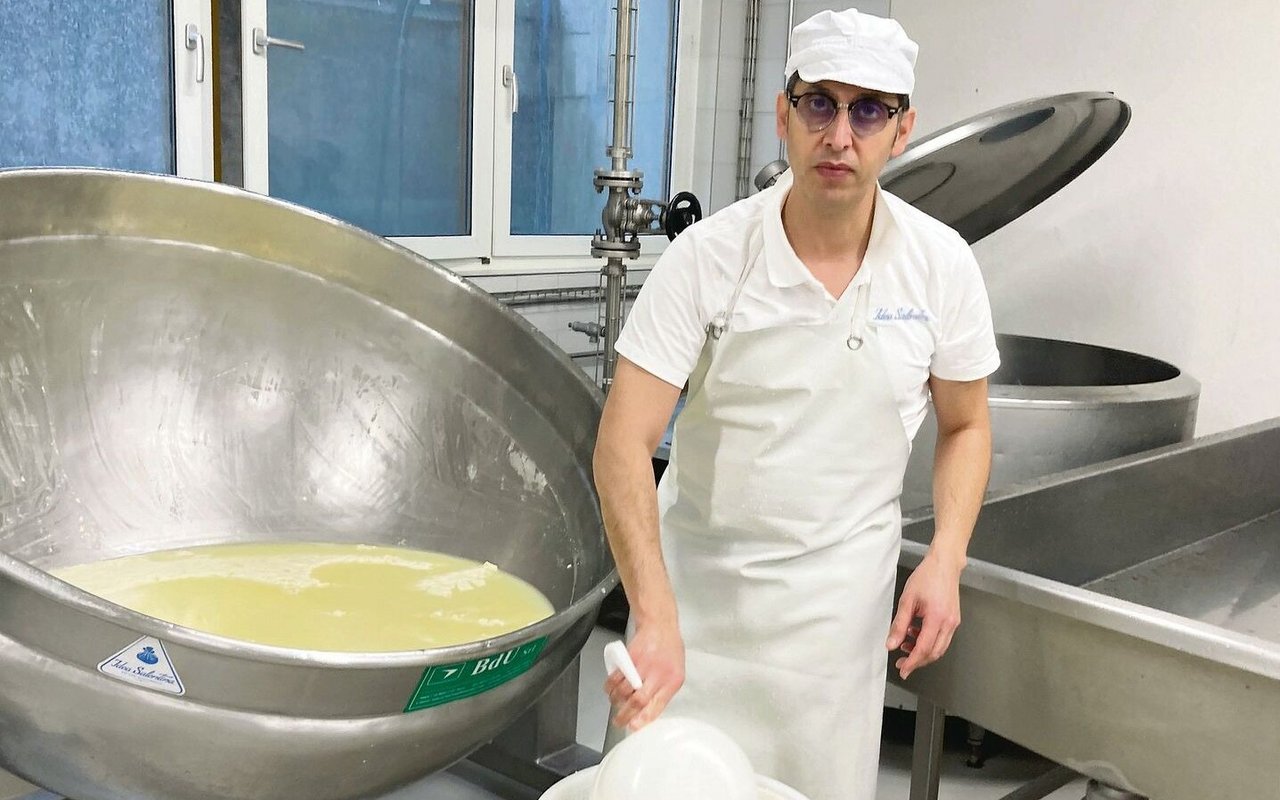 Mozzarella-Herstellung ist hier Handarbeit: Roberto De Matteis entnimmt dem Bottich den Käsebruch, um ihn anschliessend zu rühren, zu kneten und auseinander zu ziehen.