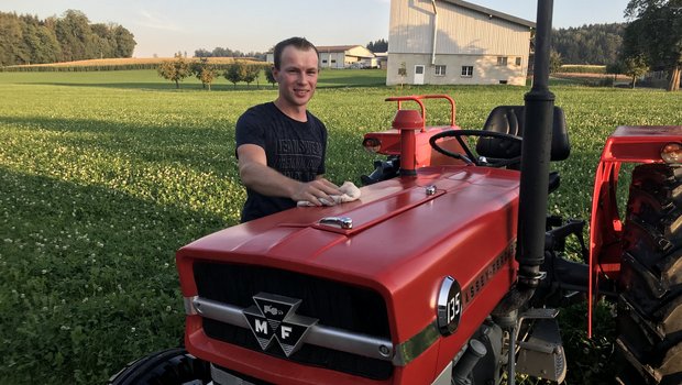 Simon Küng poliert den Massey Ferguson 135. Oldtimer-Traktoren sind eine grosse Leidenschaft von ihm, der MF wurde einst speziell für den Feuerwehreinsatz hergestellt. (Bild Franziska Jurt)