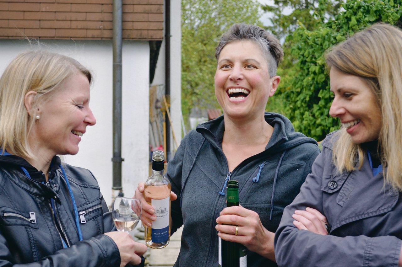 Christine Alder (Mitte) schenkt ihren Gästen vom LSV Uetendorf hofeigenen Wein aus.(Bild Franziska Schawalder)