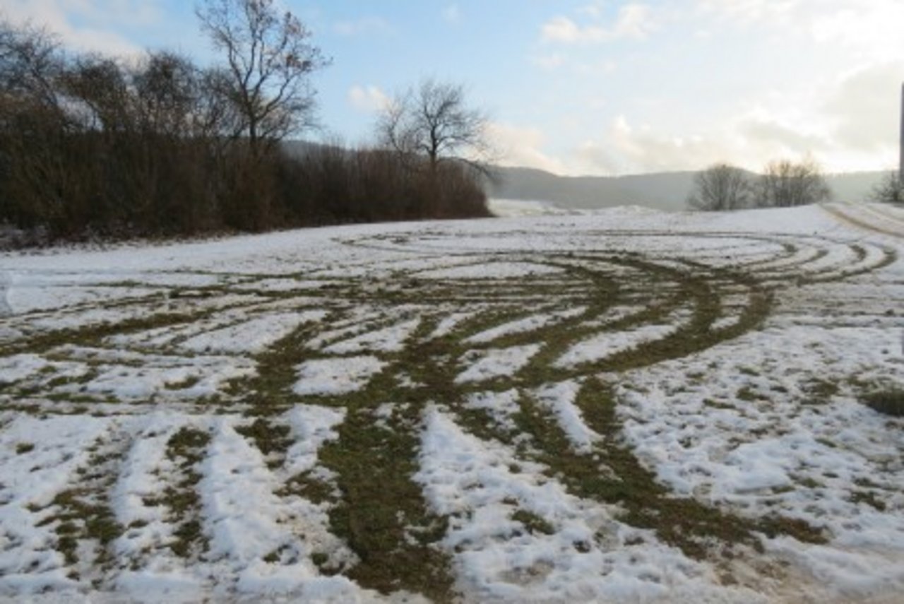 Auf dem schneebedeckten Feld sind die Spuren der Driftfahrt gut zu sehen. (Bild Kapo AG)