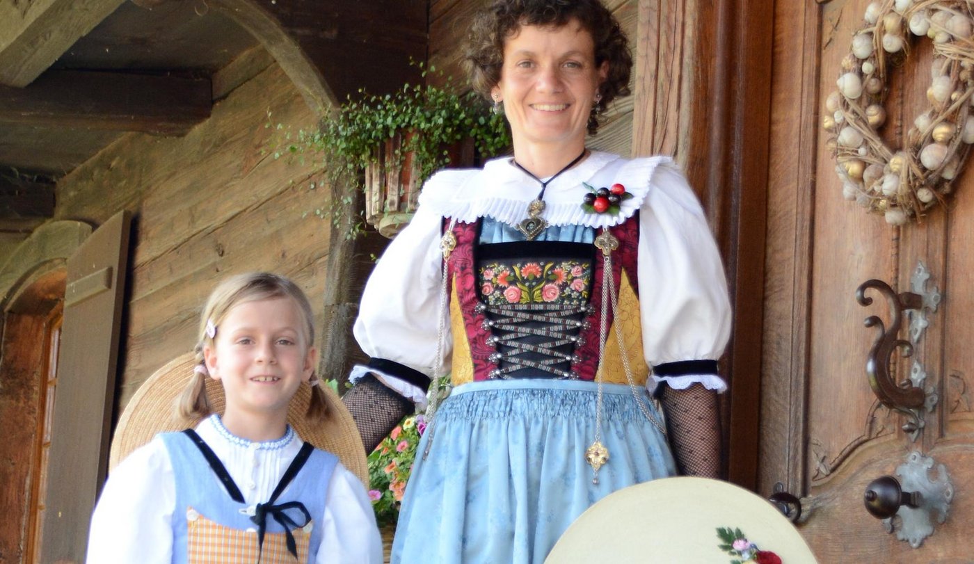 Bernadette und Tochter Angelika Hegglin in ihrer Zuger Festtags- und Mädchentracht vor dem alten Bauernhaus. (Bild Andrea Gysin)