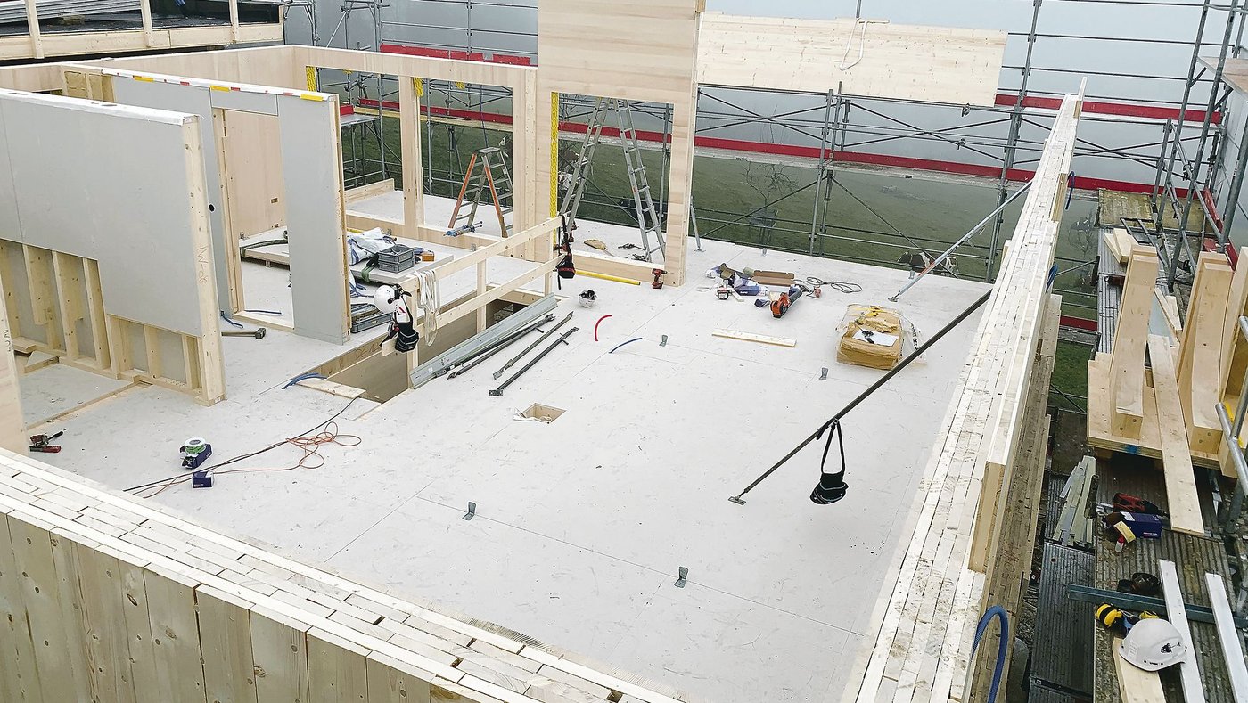 Ein Vollholzhaus entsteht. Gut ersichtlich die massiven Aussenwände aus geschichteten Holzbrettern. (Bild R. Kottmann)