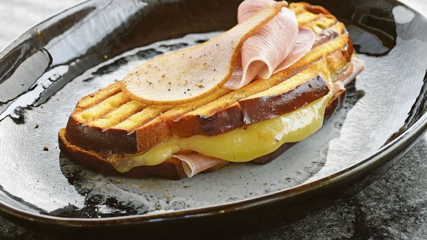 Dieser Croque trägt Dieser Croque trägt ganz die Handschrift des Kantons Freiburg. Die Cuchaule, das Freiburger Safranbrot, ist mit Vacherin Fribourgeois und Bénichonsenf gefüllt.