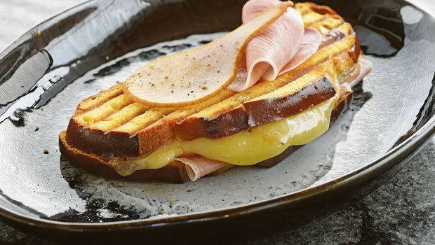 Dieser Croque trägt ganz die Handschrift des Kantons Freiburg. Die Cuchaule, das Freiburger Safranbrot, ist mit Vacherin Fribourgeois und Bénichonsenf gefüllt. 