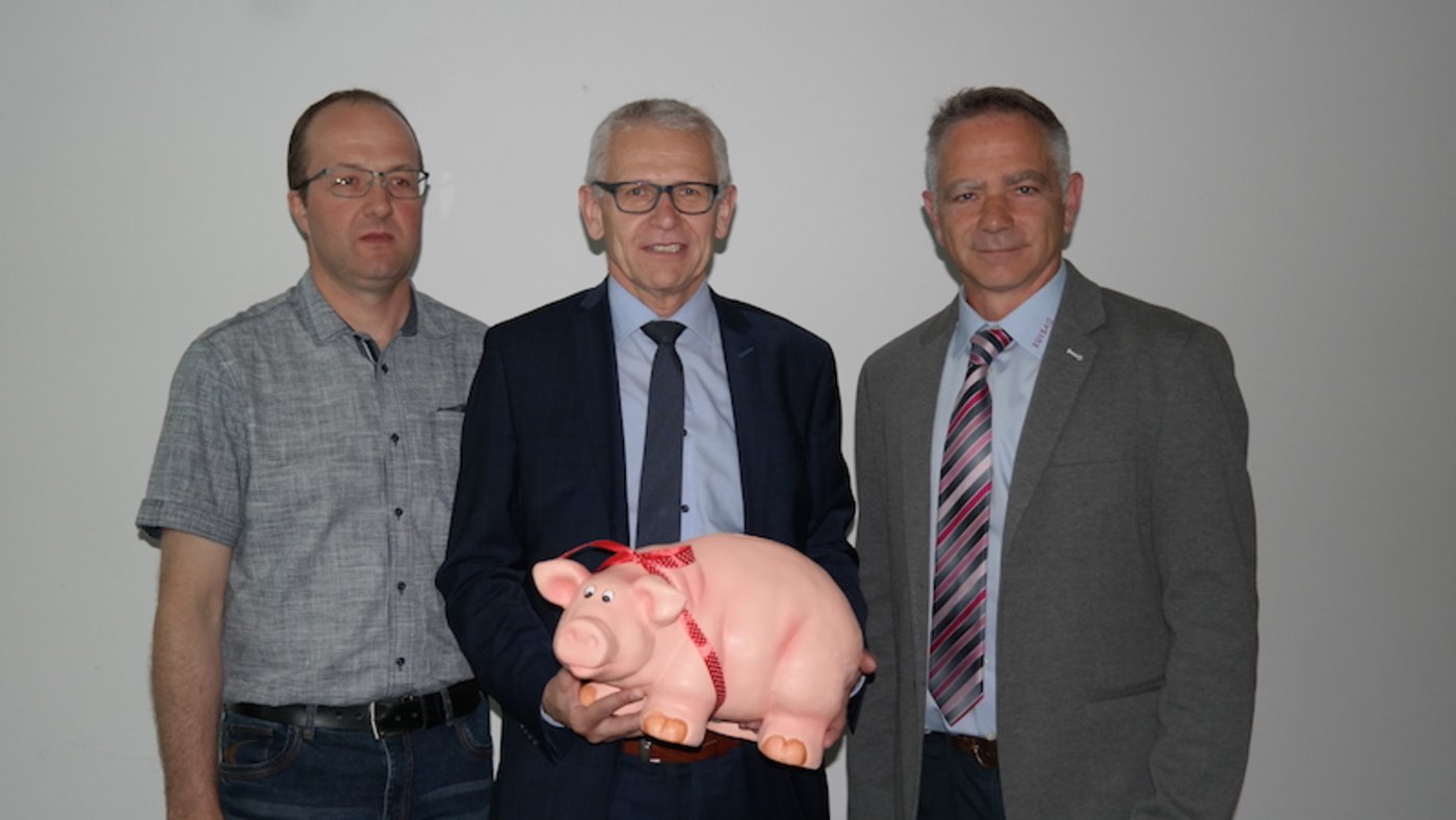 Neu in den Verwaltungsrat gewählt, von links, Toni Zwimpfer, Leo Müller mit Sparschwein, neu als Präsident und Jürg Barmettler, abtretender Suisag Präsident.