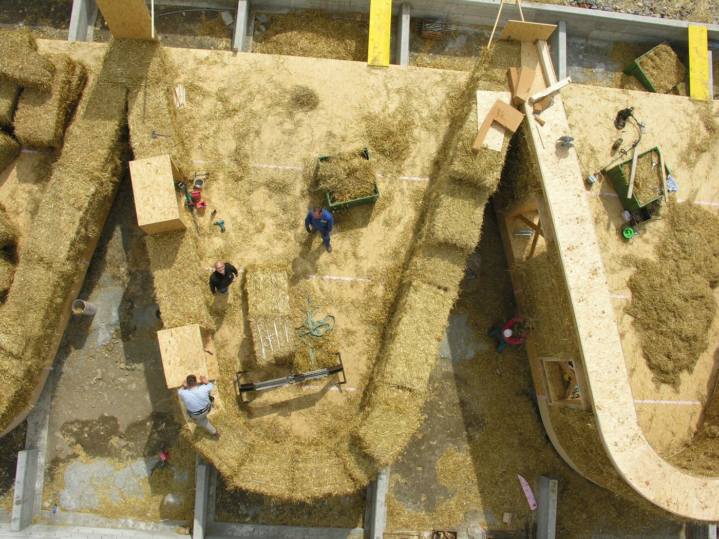 Die Strohballen bestimmen die Dicke der Wände und werden in die Holzkonstruktion eingefüllt und zugeschnitten. Das atmungsaktive Stroh wirkt wegen seiner tiefen Wärmeleitfähigkeit wärmedämmend und somit isolierend. (Bild Atelier Schmidt)