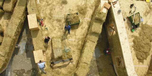 Die Strohballen bestimmen die Dicke der Wände und werden in die Holzkonstruktion eingefüllt und zugeschnitten. Das atmungsaktive Stroh wirkt wegen seiner tiefen Wärmeleitfähigkeit wärmedämmend und somit isolierend. (Bild Atelier Schmidt)