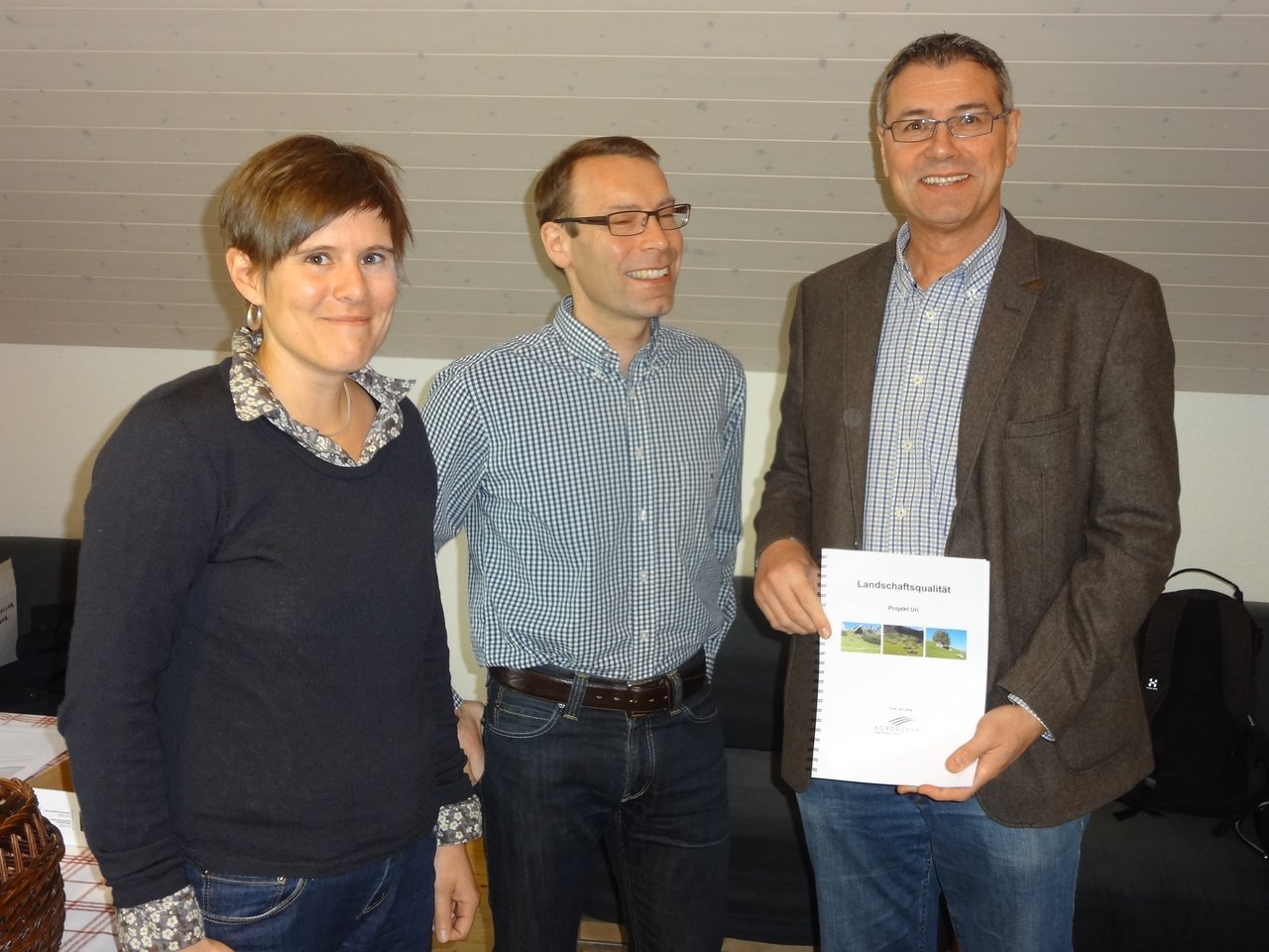 Markus Baumann vom Landwirtschaftsamt Uri überreicht das Dossier an Simon Hasler und Franziska Grossenbacher vom Bundesamt für Landwirtschaft. (v.r.)