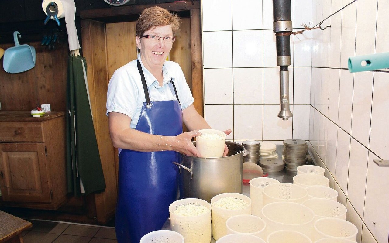 Bernadette Brunner füllt die fertige Käsemasse in die entsprechenden Formen. Dabei gibt sie Gewürze bei.