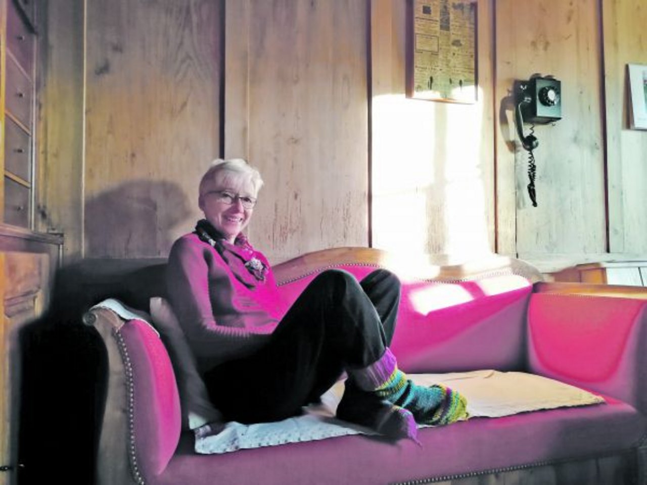 Dori Beck, die Gewinnerin der Stulpensocken, auf ihrem wunderschönen roten Sofa. (Bild zVg)