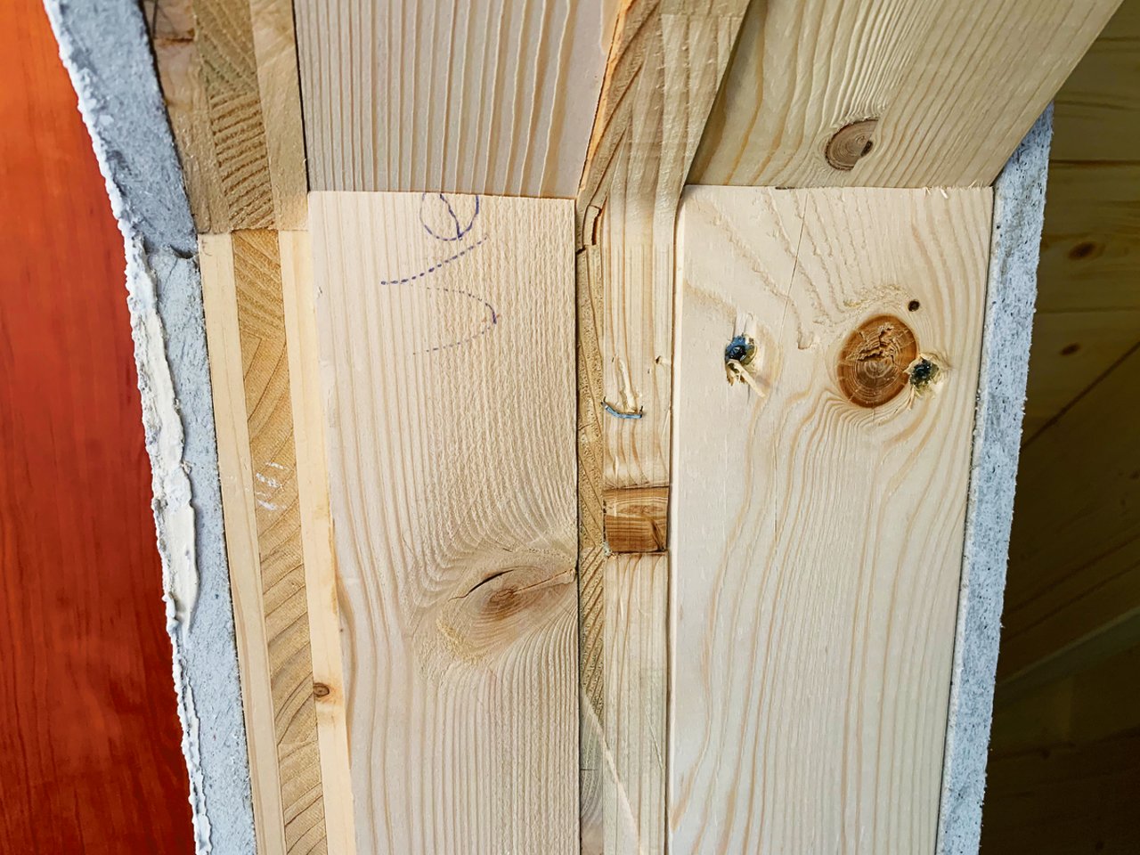 Holzhaus, aber nicht ausschliesslich Holz. Aufbau einer Innenwand mit verleimten Holzplatten, aussen Fermacell und ein Verputz. 