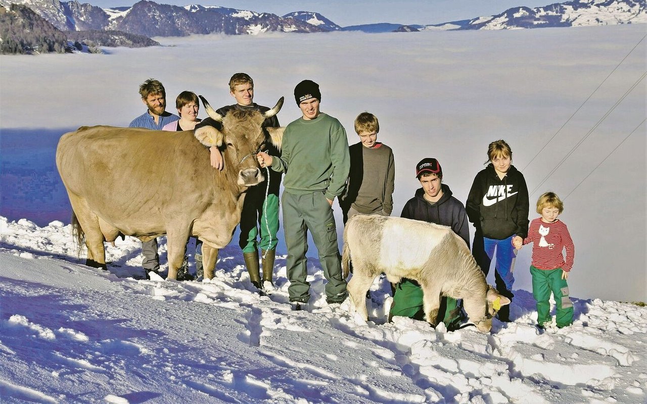 Thomas und Heidi Eberli mit David, Sandro, Marco, Jonas, Carmen und Jasmin (v. l. n. r.) sowie der OB-Kuh Alpenrose und ihrem Gurtkalb Alpina.