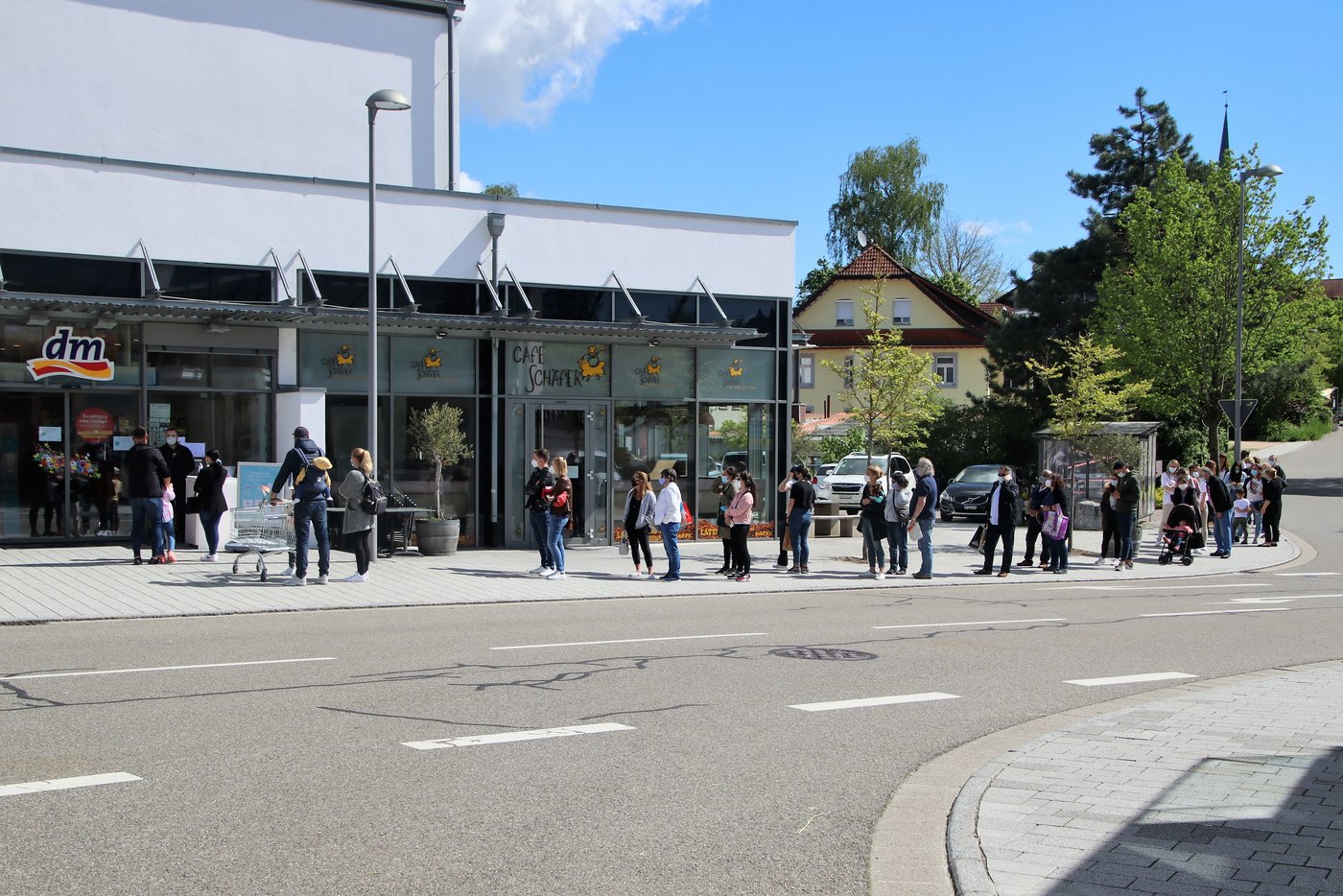 Auch in Deutschland gelten Corona-Einschränkungen. Die Schlangen vor den Läden sind beachtlich. 