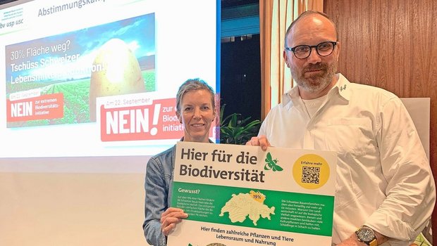 Thomas Rickenbacher und Sandra Helfenstein präsentieren das Plakat, dass auf Höfen auf die vielen bereits bestehenden Biodiversitäts-Förderflächen hinweisen soll. 