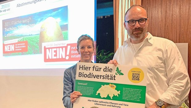 Thomas Rickenbacher und Sandra Helfenstein präsentieren das Plakat, dass auf Höfen auf die vielen bereits bestehenden Biodiversitäts-Förderflächen hinweisen soll.