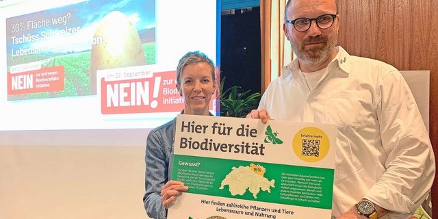 Thomas Rickenbacher und Sandra Helfenstein präsentieren das Plakat, dass auf Höfen auf die vielen bereits bestehenden Biodiversitäts-Förderflächen hinweisen soll. 