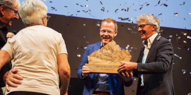 Die Gewinner des Prix Montagne 2018: La Conditoria aus Sedrun/GR. Reto Schmid, Inhaber der Conditoria, nimmt von Jury-Präsident Bernhard Russi den Preis entgegen. (Bild Schweizer Berghilfe)