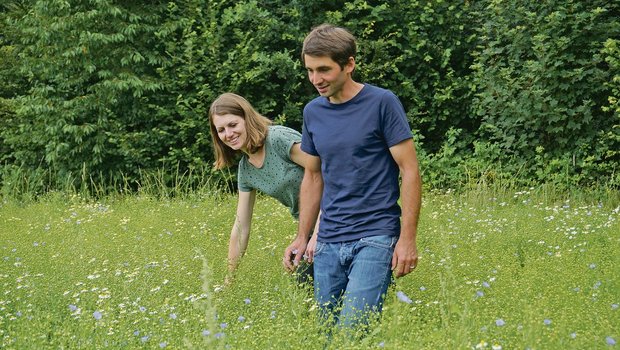 Anja und Reto Widmer spazieren über ein Feld mit Öllein. Die beiden bewirtschaften ihren gemeinsamen Biohof in Heimiswil seit 2016. Seither haben sie den Betrieb schrittweise weiterentwickelt und vielseitiger gemacht.(Bild Deborah Rentsch)