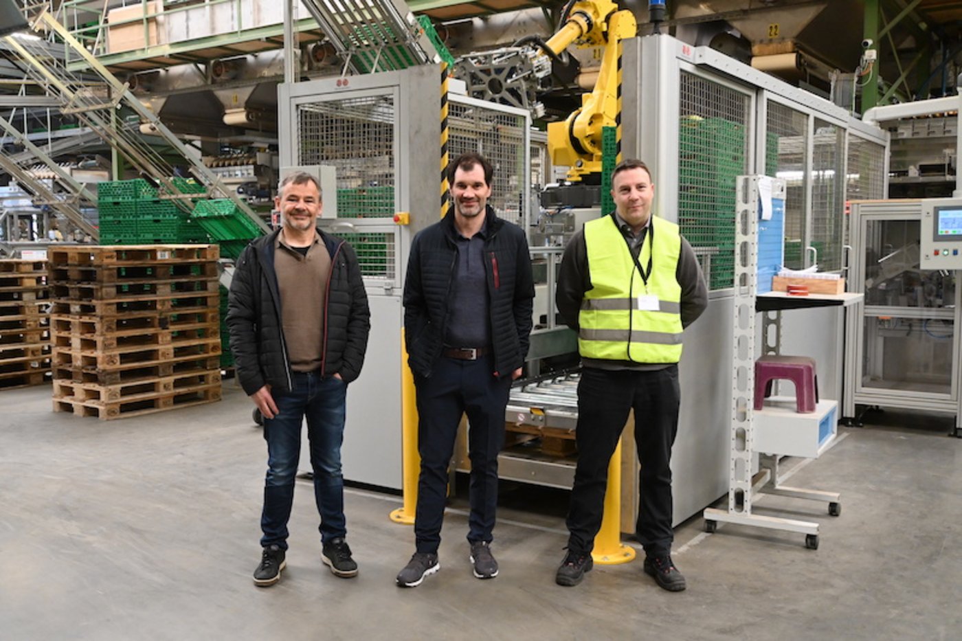Jörg Schär (Fenaco), Klaus Meier (Steffen-Ris) und Daniel Studer von Twin Automation vor der neuen Roboterzelle im Packzentrum in Bätterkinden (Bilder jba)