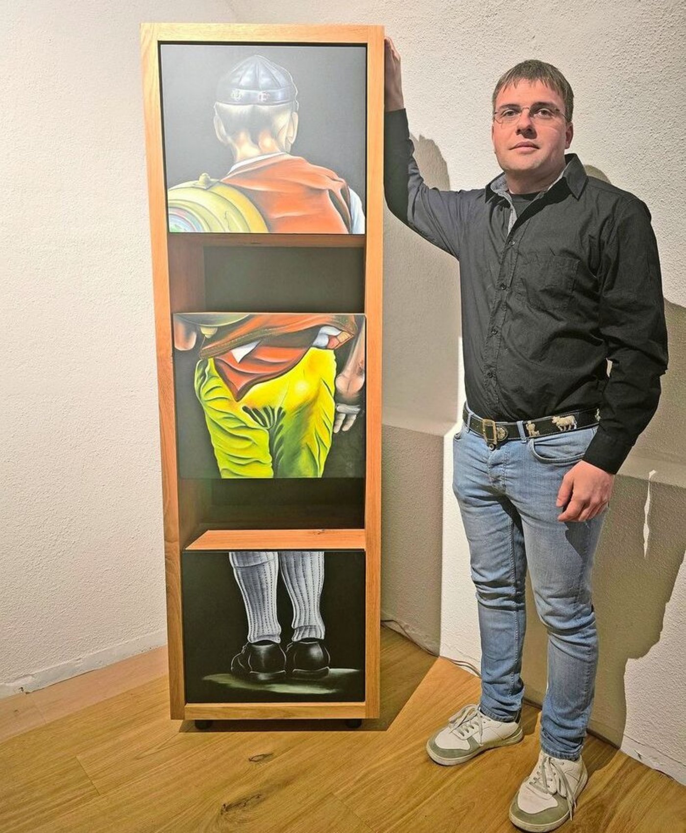 Ein Appenzeller Senn in der typischen gelben Hose ziert dieses Regal. Trachten und ihre Details sind ein beliebtes Motiv von Stefan Manser.