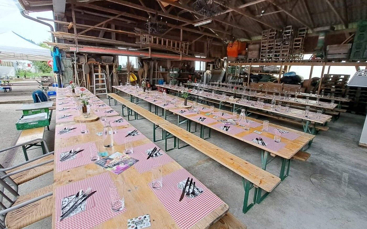 Aus- und aufgeräumte Remise mit gedeckten Tischen, bereit für den Brunch auf dem Betrieb Wyssrüti. 