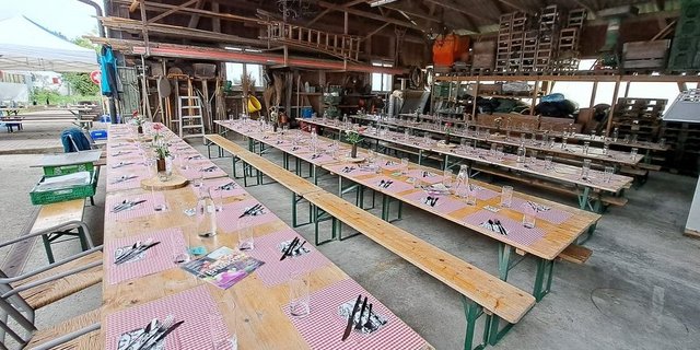Aus- und aufgeräumte Remise mit gedeckten Tischen, bereit für den Brunch auf dem Betrieb Wyssrüti. 