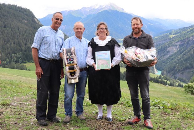 Gewinner des Bio-Bruna-Awards 2020: «Der Einsatz wurde belohnt» Als Anerkennung ihrer Leistung wurden Toni (mit Glocke) und Nicole Sigron (mit Bio Bruna Award) von Marco Parpan (l.) Lucas Margreth (r.) mit einem Früchtekorb beschenkt. (Bild vcd)