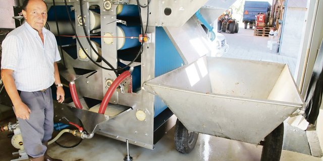 Ernst Bachmann beim Sammelbehälter unter der Presse. Im Behälter wird der frisch gepresste Saft aufgefangen. Danach wird er zum Klären und Abfüllen abgepumpt.(Bilder Roland Müller)