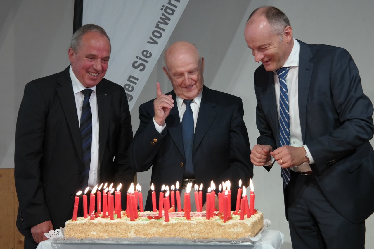 Die Geburtstagstorte mit dem drei Anicom-Präsidenten, von links, Eugen Brühlmeier, Gründerpräsident Max Tschannen und heutiger Präsiden Heinz Mollet. (Bild Josef Kottmann)