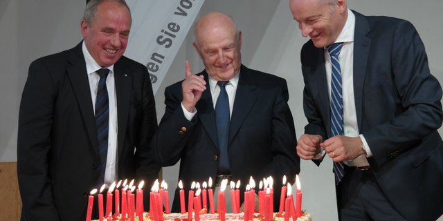 Die Geburtstagstorte mit dem drei Anicom-Präsidenten, von links, Eugen Brühlmeier, Gründerpräsident Max Tschannen und heutiger Präsiden Heinz Mollet. (Bild Josef Kottmann)